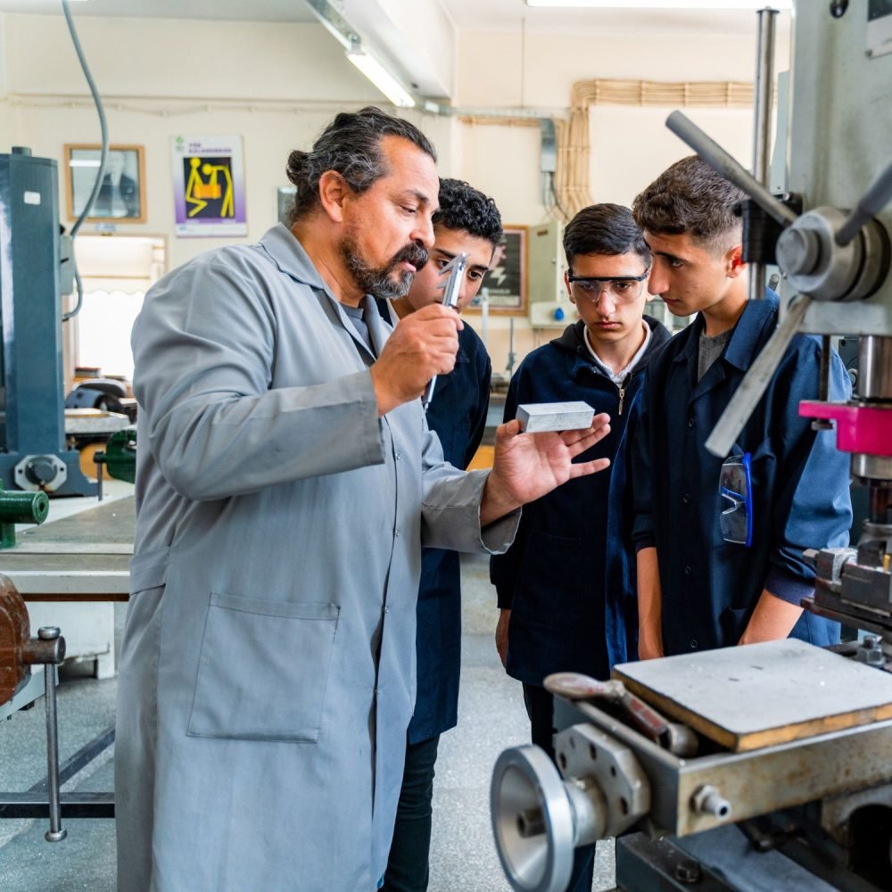 Jeune en formation pratique (avec casque, ordinateur, tenue pro) Alternance, sécurité, métiers qualifiants